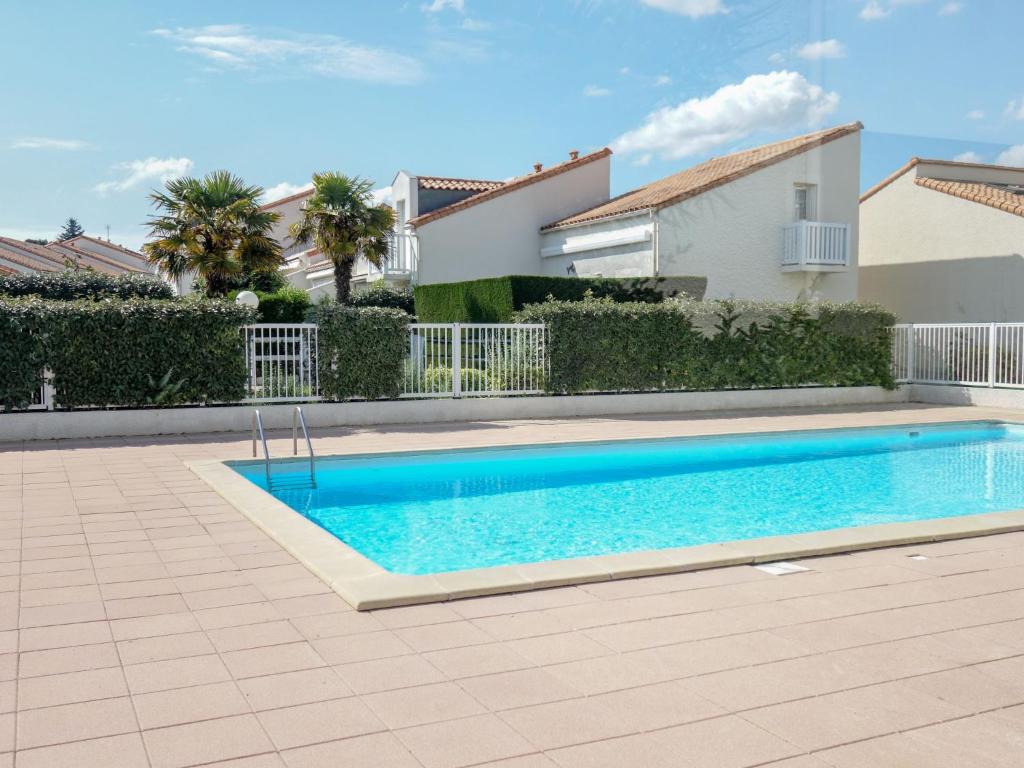 a swimming pool in front of a house at Apartment Les Jardins de l'Océan-42 by Interhome in Vaux-sur-Mer