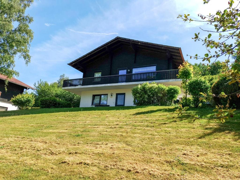 a house with a gambrel roof on top of a yard at Apartment Ferienpark Himmelberg-4 by Interhome in Thalfang