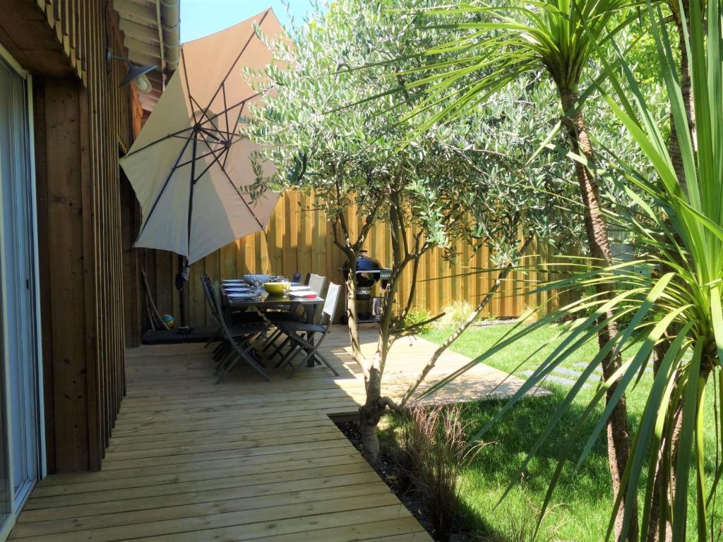 a patio with a table and an umbrella at Holiday Home Le Chant Des 4 Sirènes by Interhome in La Teste-de-Buch