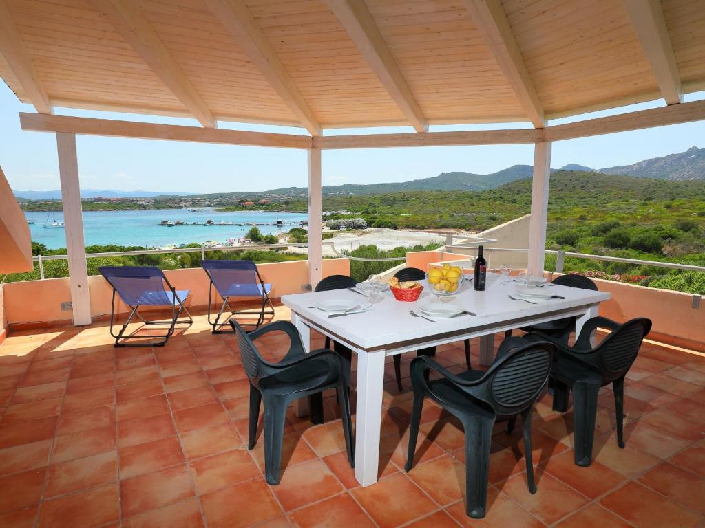 a table and chairs on a patio with a view of the ocean at Apartment Vista Playa 1 by Interhome in Golfo Aranci