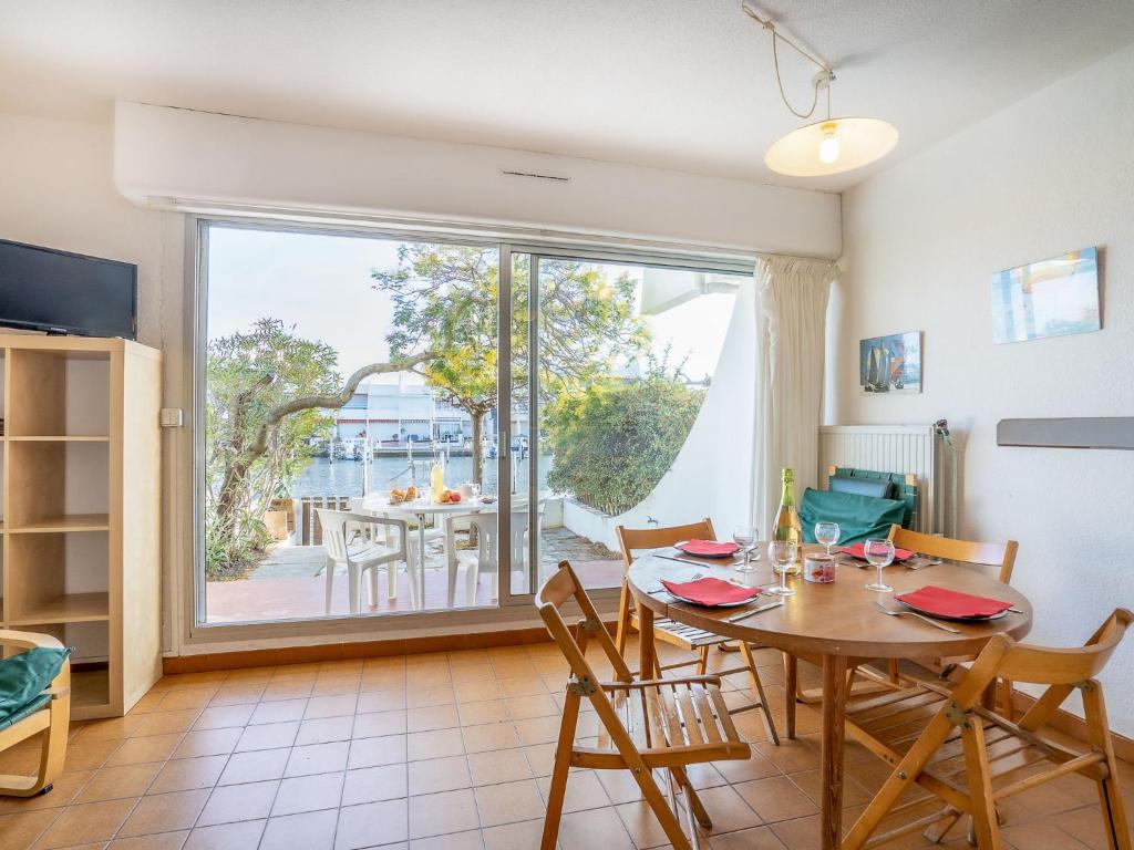 une salle à manger avec une table et une grande fenêtre dans l'établissement Apartment Les Marinas de la Plage II by Interhome, au Grau-du-Roi