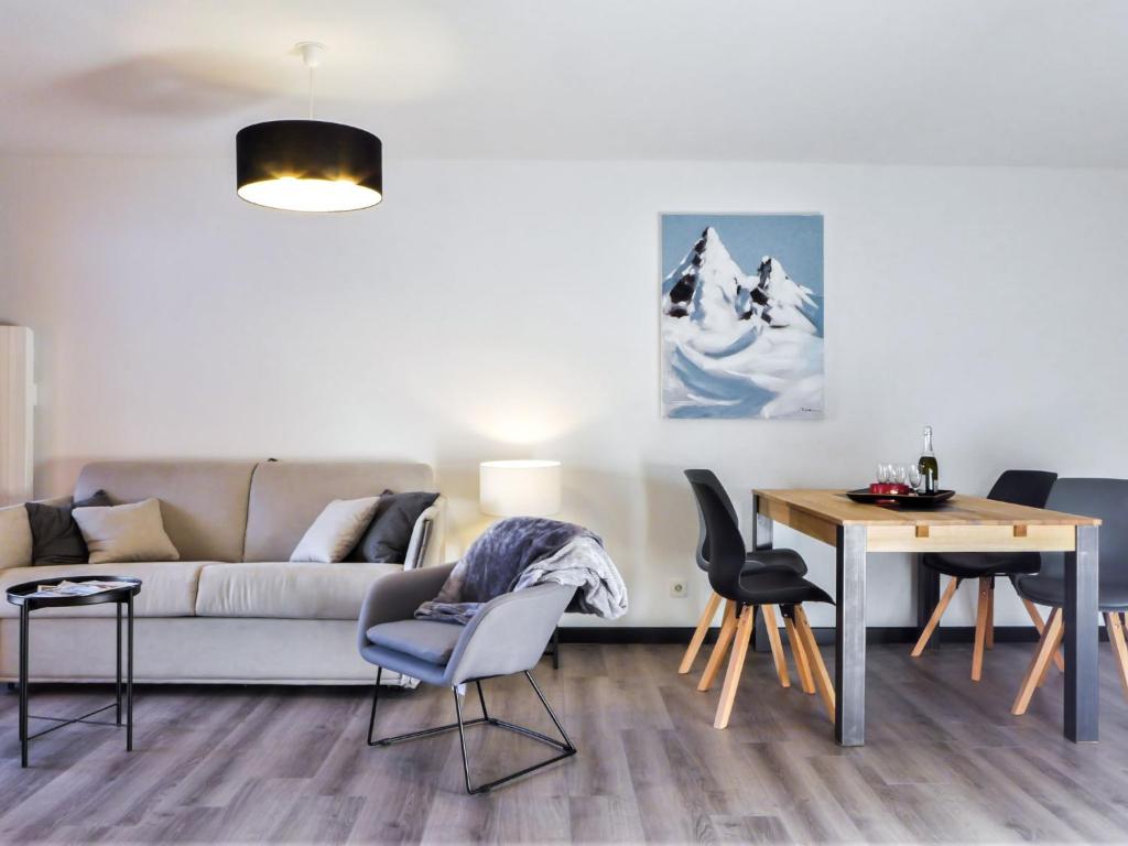 un salon avec un canapé, une table et des chaises dans l'établissement Apartment L'Espace Montagne-16 by Interhome, à Chamonix-Mont-Blanc