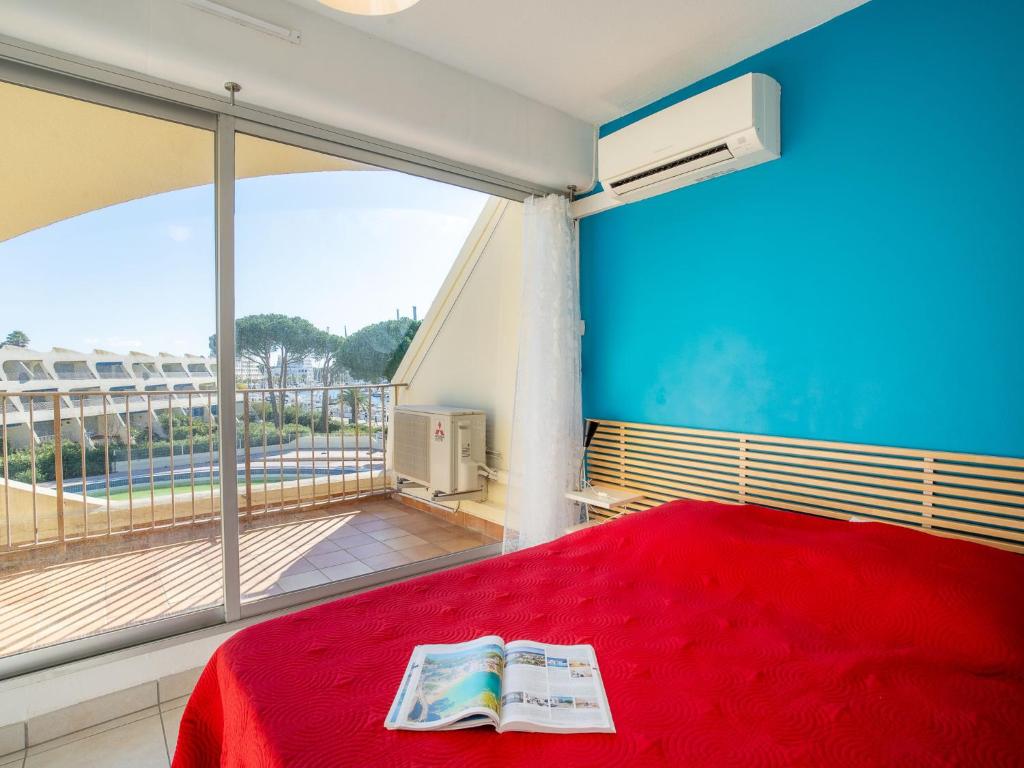 une chambre avec un lit rouge et une grande fenêtre dans l'établissement Apartment Le Grand Galion-2 by Interhome, au Grau-du-Roi