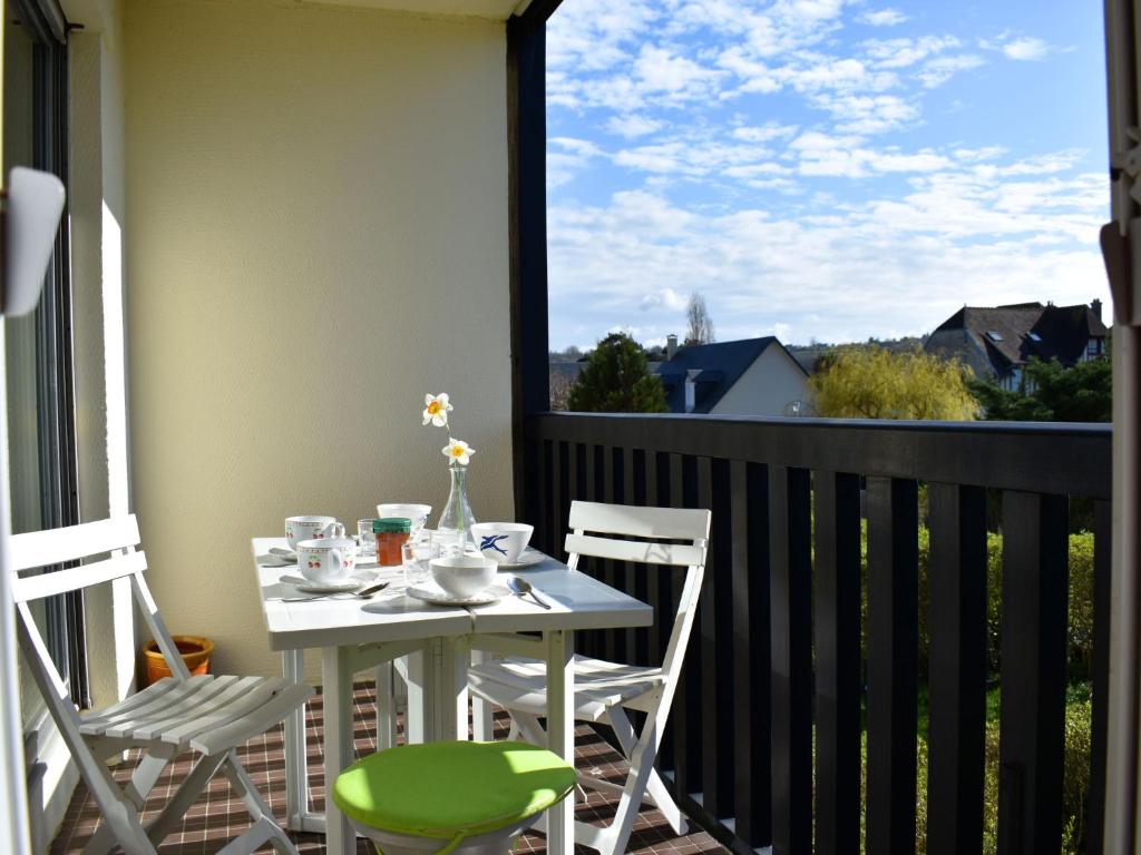 d'une table et de chaises blanches sur un balcon avec fenêtre. dans l'établissement Apartment Les Terrasses de Tourgeville-3 by Interhome, à Tourgéville
