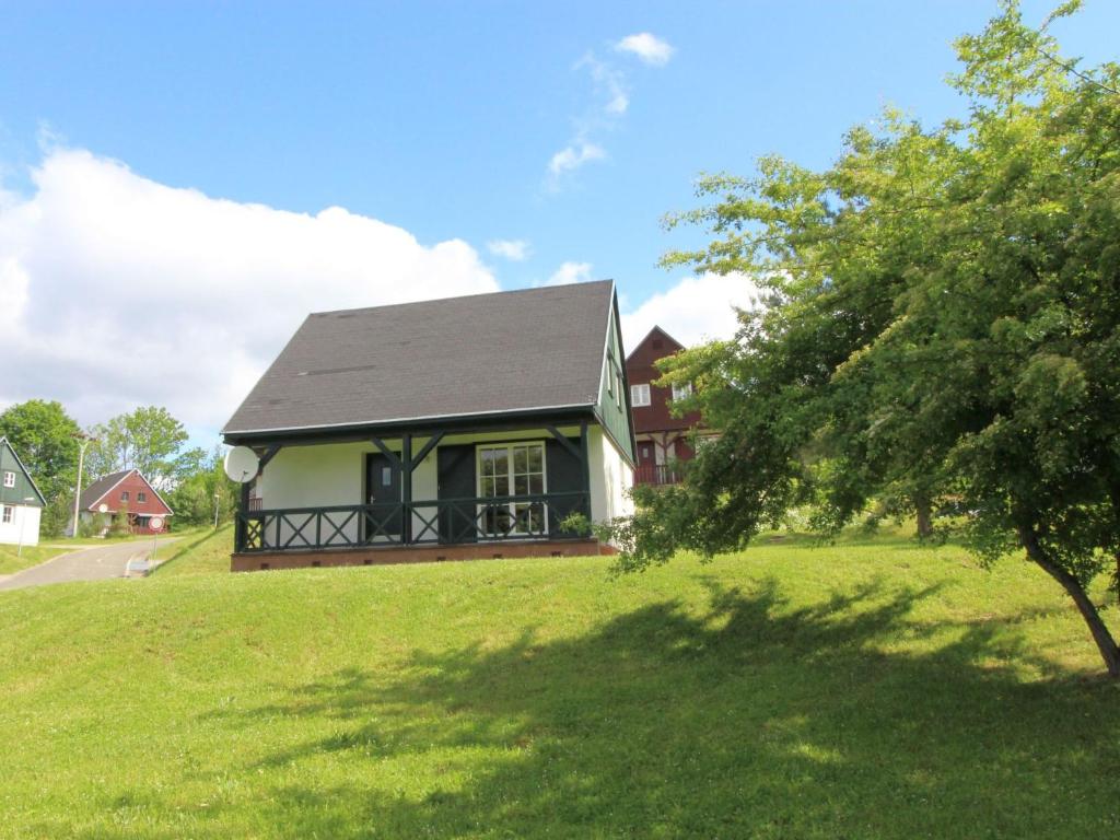 une maison sur un champ verdoyant avec un arbre dans l'établissement Holiday Home Holiday Hill 36 by Interhome, à Lauterwasser