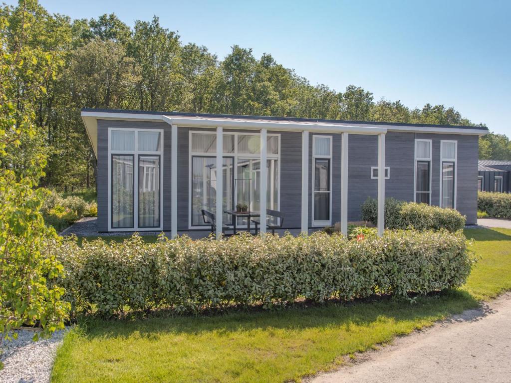 ein winziges Haus mit Garten gezeigt wird in der Unterkunft Holiday Home Water Resort Oosterschelde - huisnr- 93 by Interhome in Wemeldinge