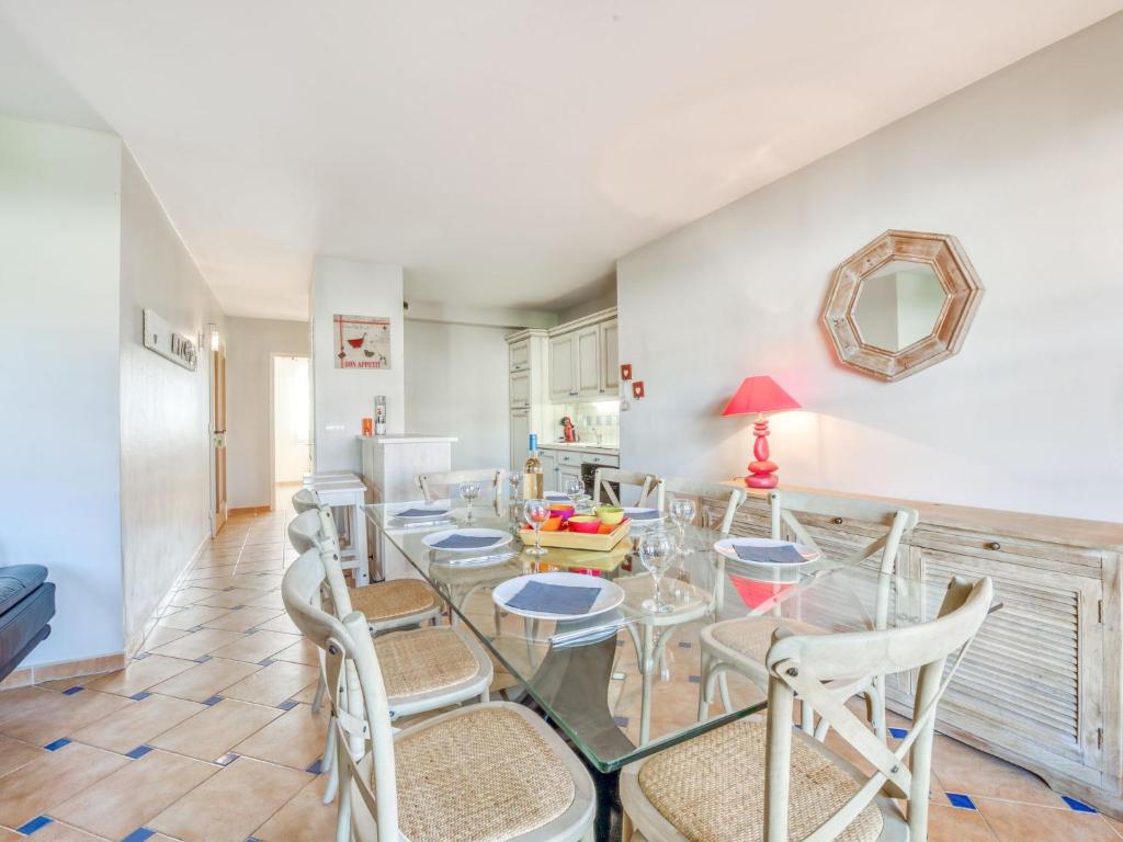 une salle à manger avec une table et des chaises en verre dans l'établissement Apartment Le Clos des Vignes by Interhome, à La Môle