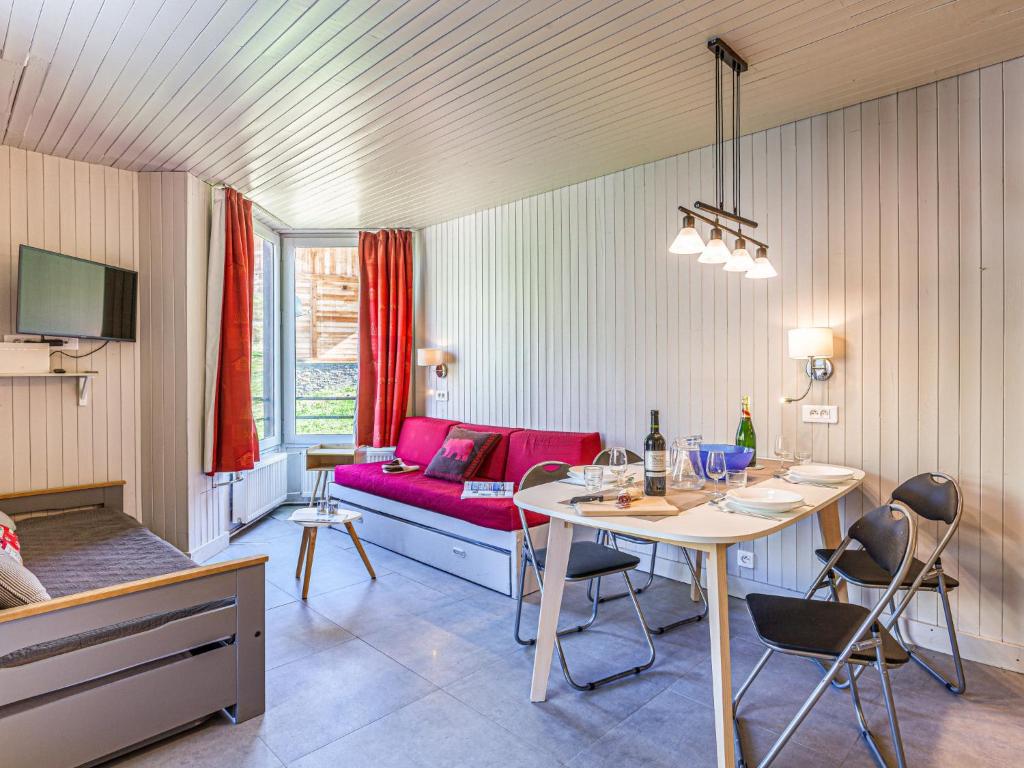 un salon avec une table et un canapé rouge dans l'établissement Apartment Le Grand Pré - Lavachet-6 by Interhome, à Tignes