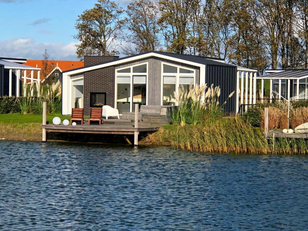 a house on a dock next to a body of water at Holiday Home Vakantiehuis Ruisweg 62 by Interhome in Wemeldinge