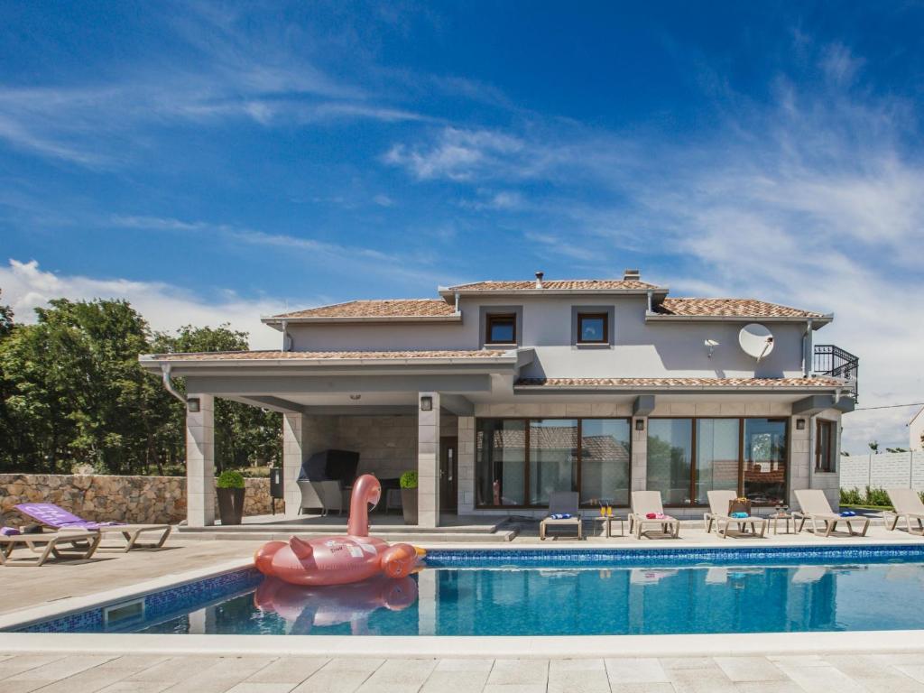 a house with a swimming pool in front of a house at Villa Oasis of peace by Interhome in Gornji Proložac
