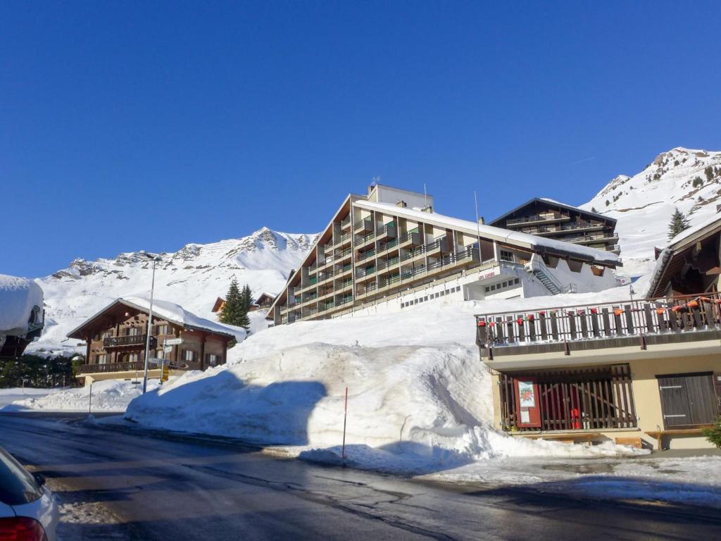 um edifício com neve no lado de uma rua em Apartment Les Cimes by Interhome em Les Crosets