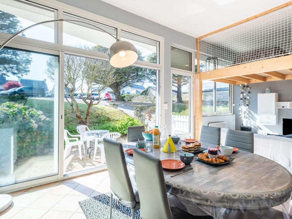 a dining room with a table and chairs and windows at Apartment Beaumanoir by Interhome in Quiberon
