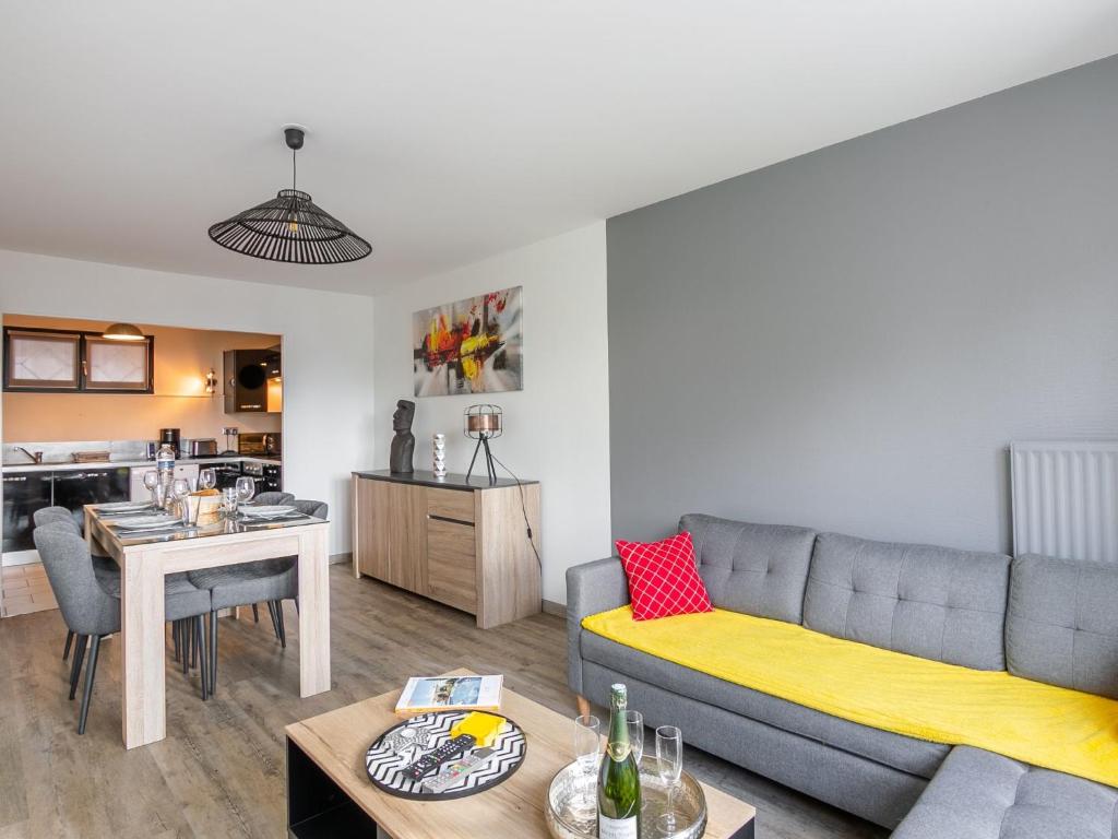 een woonkamer met een bank en een tafel bij Apartment Les grands jardins by Interhome in Saint-Malo