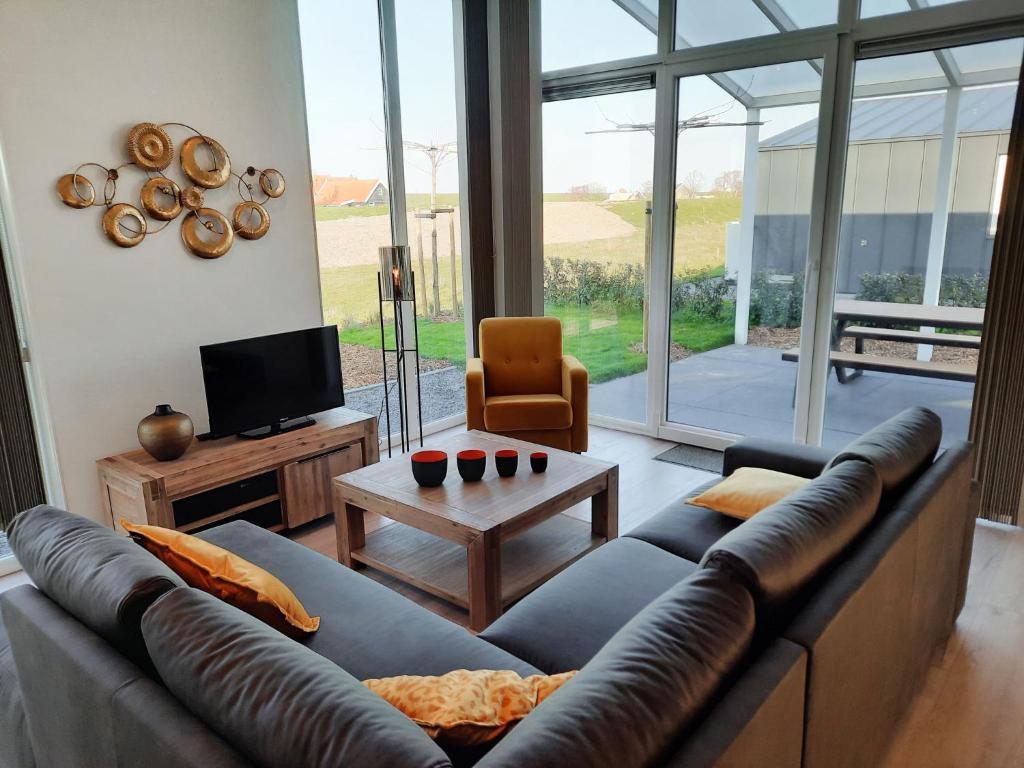 een woonkamer met een leren bank en een tafel bij Holiday Home Vakantiehuis Ruisweg 83 by Interhome in Wemeldinge