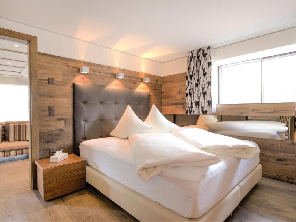 ein Schlafzimmer mit einem großen weißen Bett mit weißen Kissen in der Unterkunft Apartment Chesa Piz Mezdi - St- Moritz by Interhome in St. Moritz