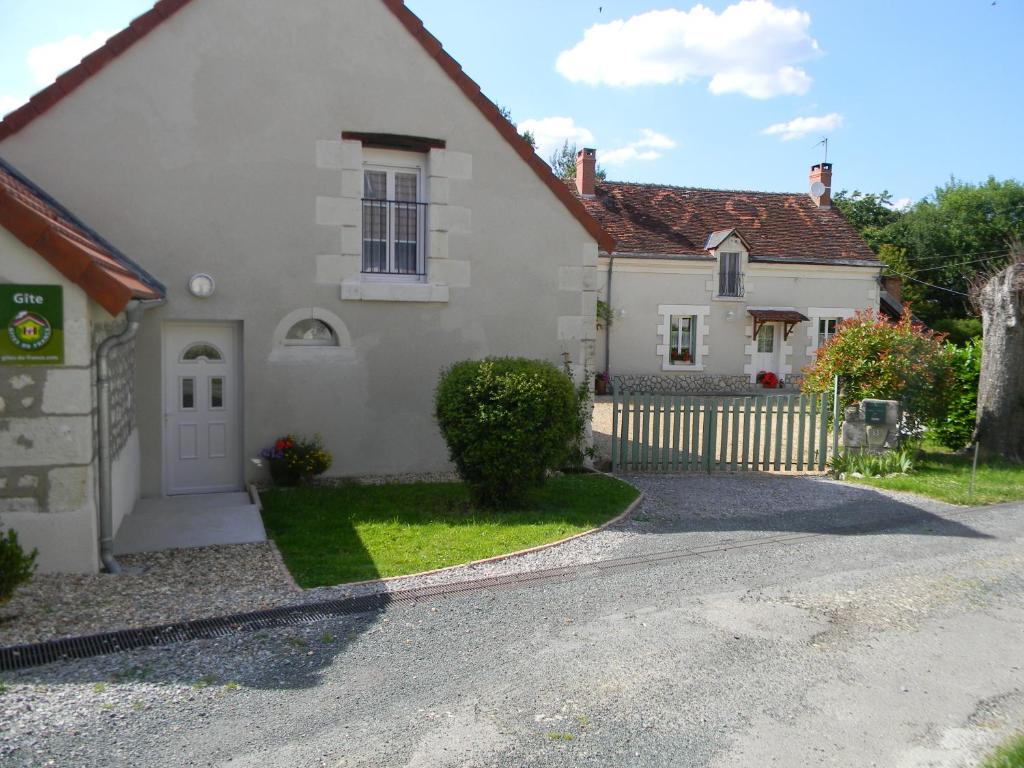 a white house with a fence and a driveway at Gite - Chambres d'Hôtes Faverolles in Faverolles