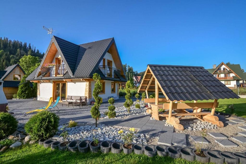 a house with a solar roof and a playground at Tatrzanskie domki in Poronin