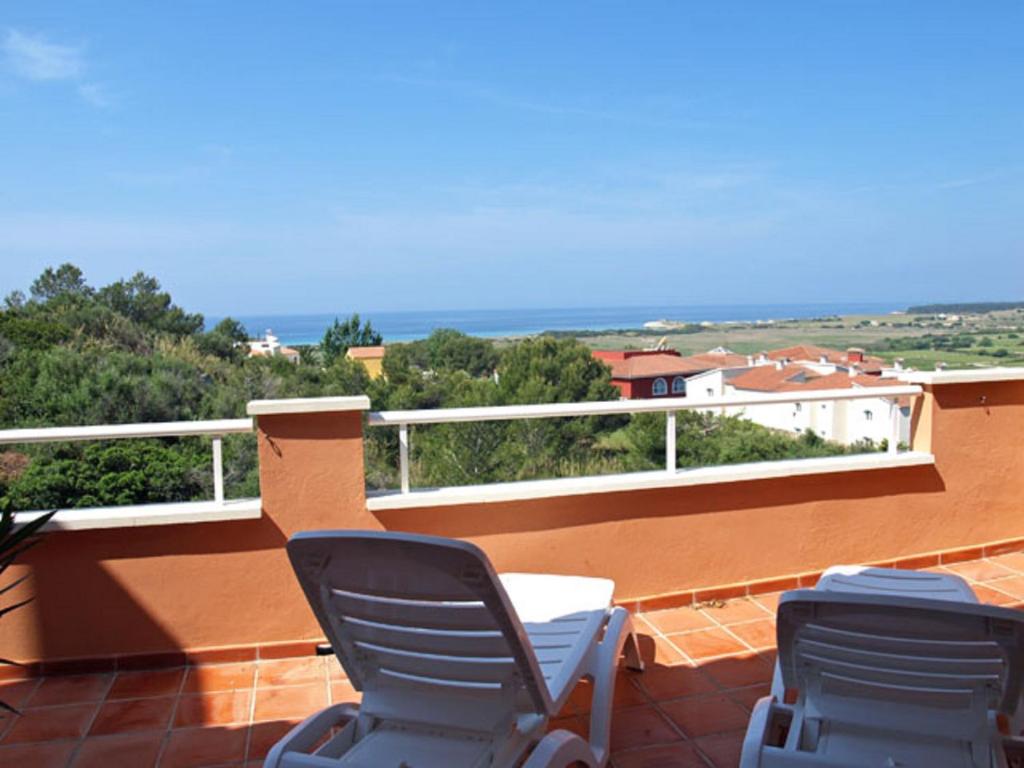 dwa krzesła na balkonie z widokiem na ocean w obiekcie EL MIRADOR w mieście Alaior