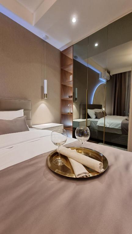 a hotel room with a bed and two glasses on a table at Belgrade Waterfront-Beograd na vodi - BW Arcadia Lux in Belgrade