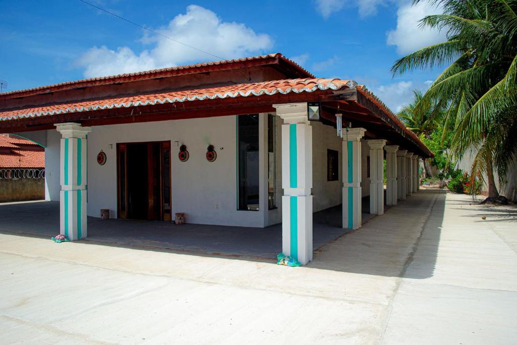 um edifício com colunas azuis e brancas num passeio em Casa perto da Praia Canto da Barra em Fortim CE em Fortim
