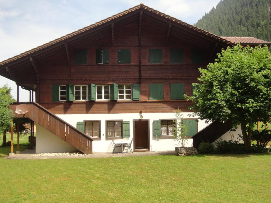 a house with a staircase in front of it at Ferienwohnung Lenk in Lenk