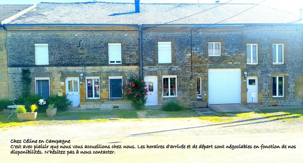 an old brick building with two white garage doors at CHEZ CELINE en campagne in Mazerny
