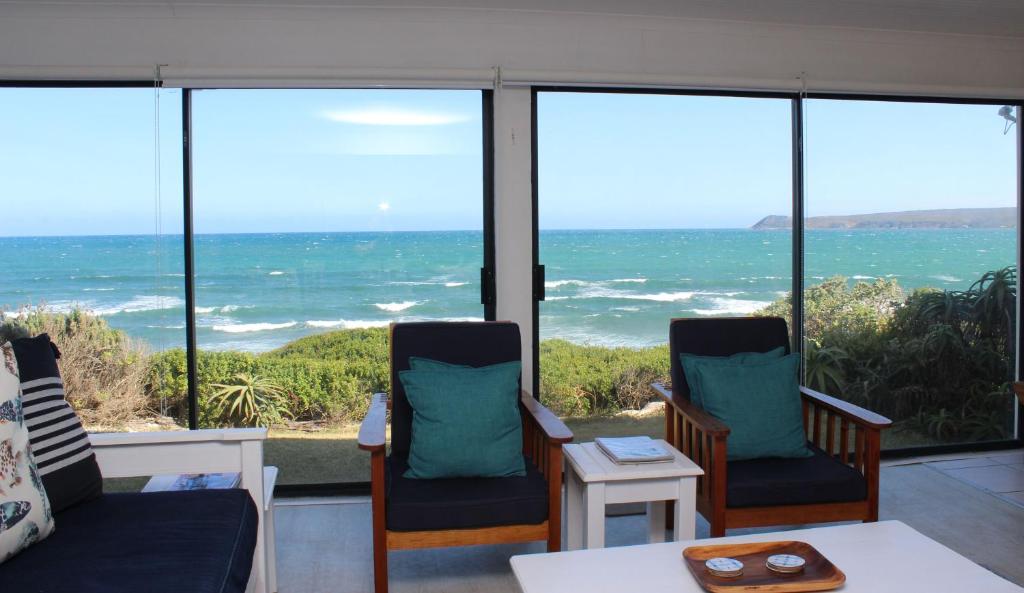 a living room with a view of the ocean at Baby Whale Bliss - Beachfront House in Witsand