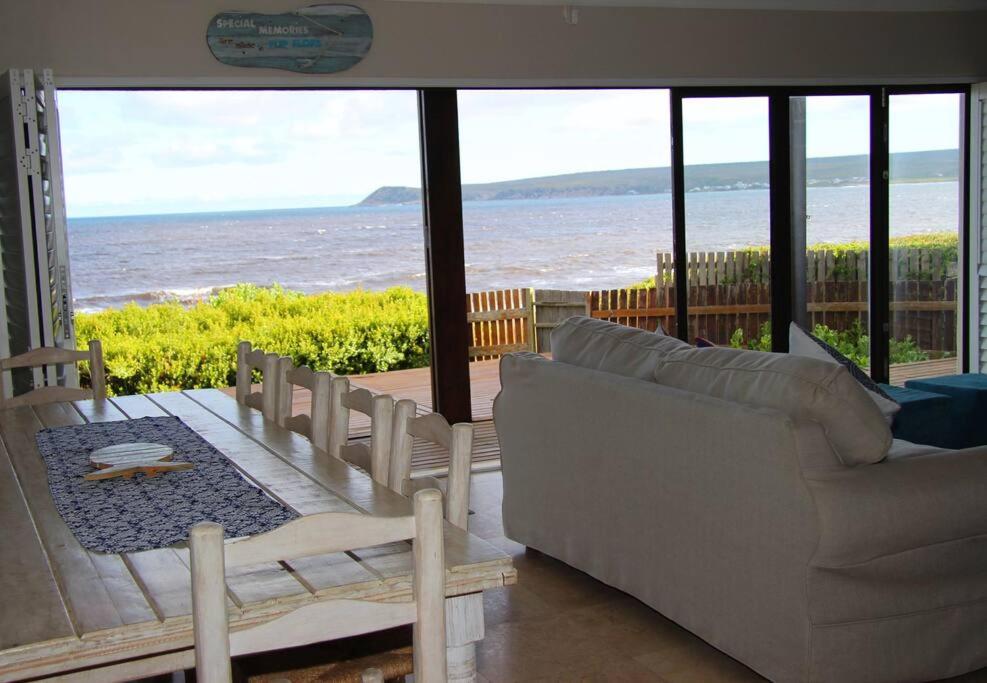 sala de estar con sofá y vistas al océano en CASA MIA, en Witsand