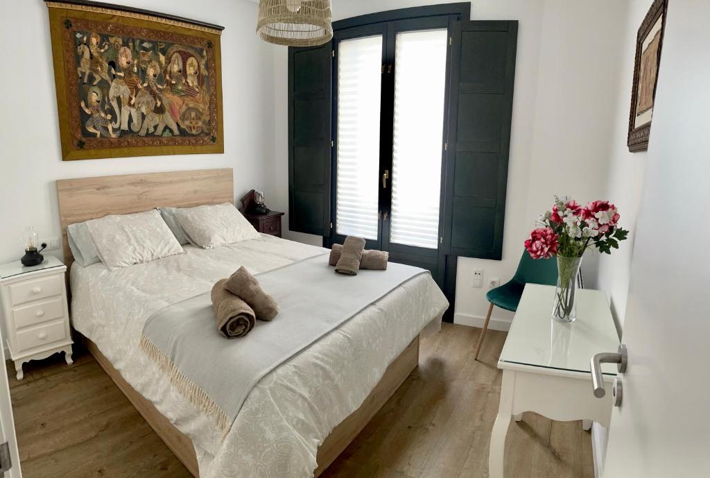 a bedroom with a bed and a vase of flowers at Afiador in Ourense
