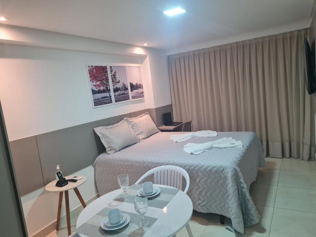 a hotel room with a bed and a table at Flat no Guest Manaíra Apart Hotel in João Pessoa