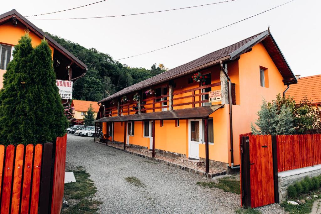 a building with a red fence in front of it at Iris Panzio in Praid