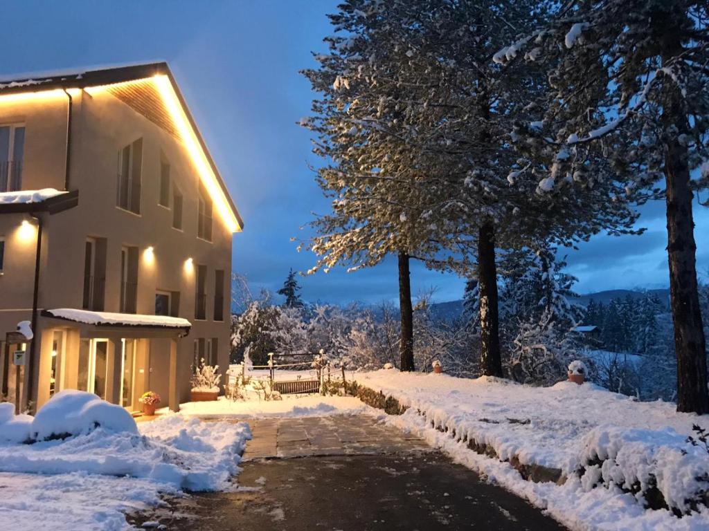 a house with snow on the ground next to a building at Relais Chalons d’Orange in Pescasseroli