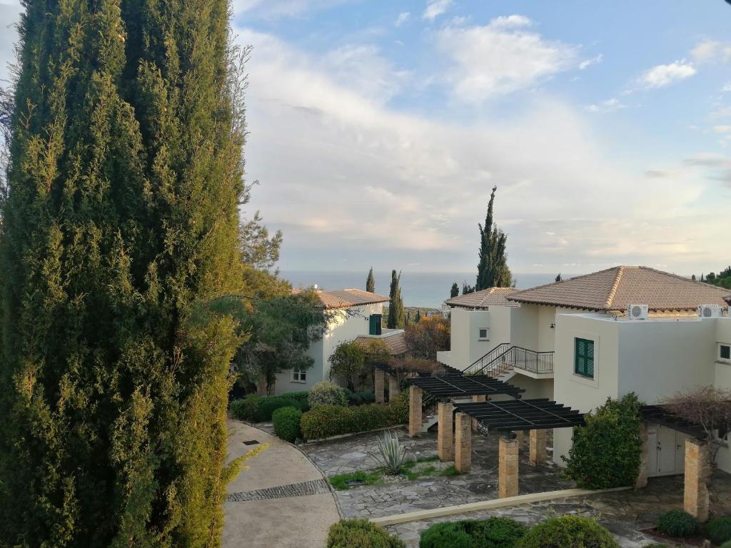 a view of a villa with a large tree at Aphrodite Hills Adonis Apartment in Kouklia