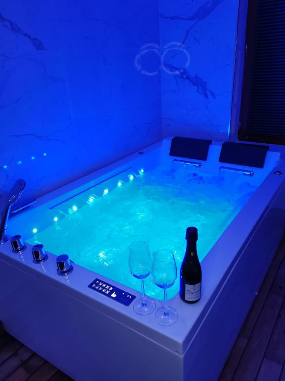 - un bain à remous avec des verres et une bouteille de vin dans l'établissement Ô Cœur de Troyes - Bulles & Spa 4 étoiles, à Troyes