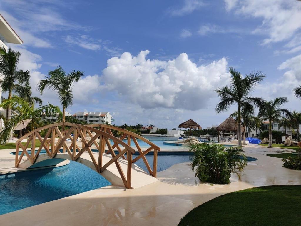 eine Holzbrücke über einen Pool in einem Resort in der Unterkunft Bliss at Puerto Aventuras in Puerto Aventuras