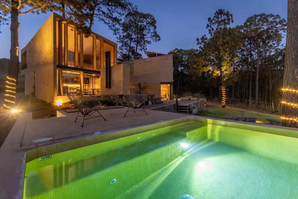 una piscina di fronte a una casa di Cabaña de lujo moderna con Alberca climatizada Mazamitla bosque 1 a Mazamitla