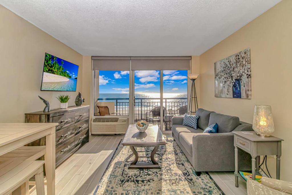 een woonkamer met een bank en uitzicht op de oceaan bij Oceanfront 1 Bedroom 2 Bath Suite Boardwalk 439 in Myrtle Beach