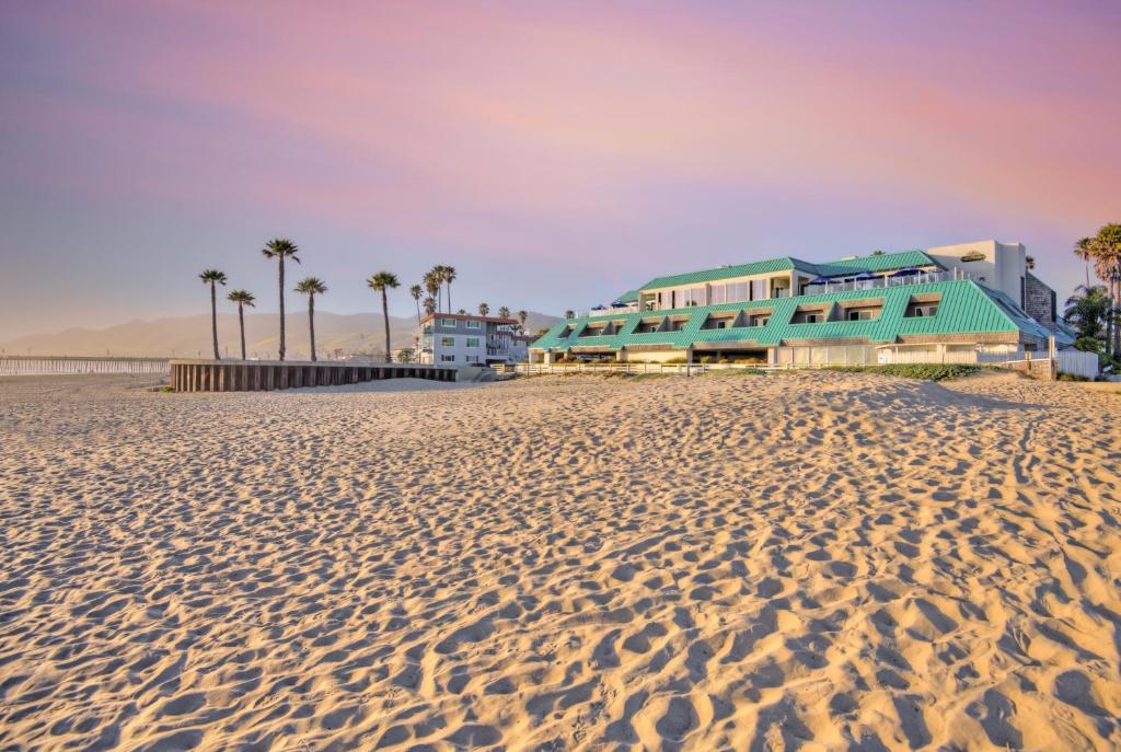 plaża z palmami i budynkami na niej w obiekcie SeaVenture Beach Hotel w mieście Pismo Beach