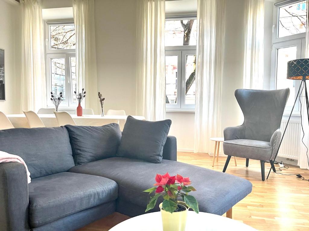 - un salon avec un canapé bleu et deux chaises dans l'établissement BIG Apartment Vienna, à Vienne