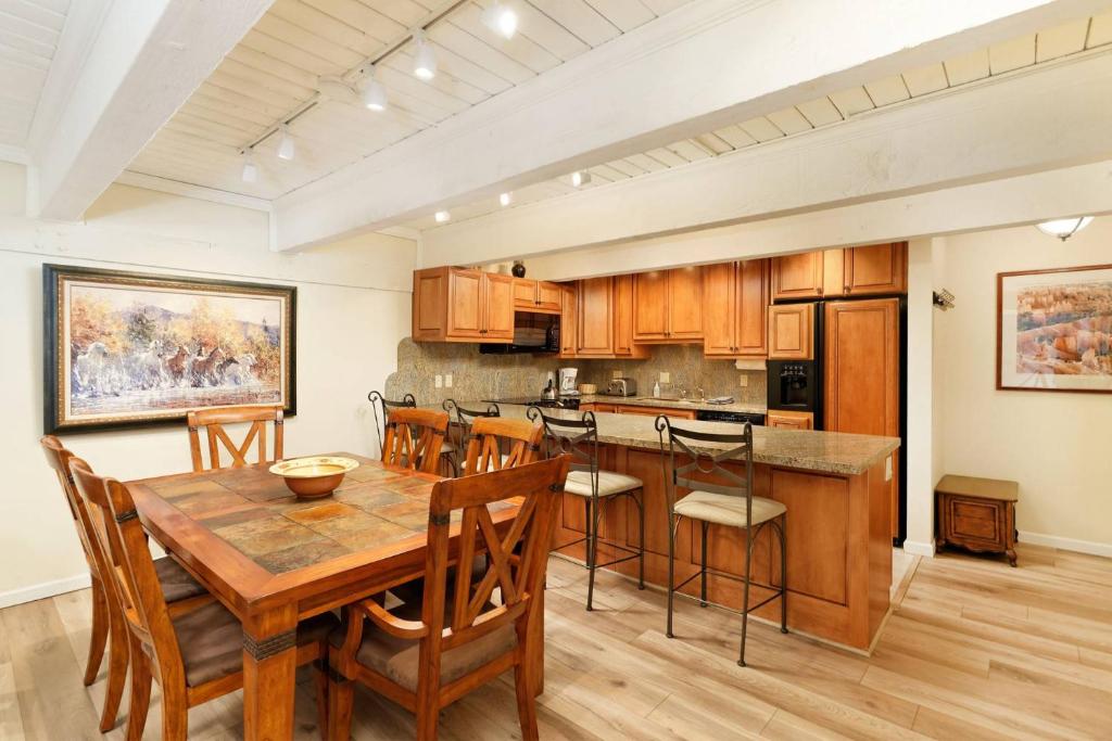 a large kitchen with a wooden table and chairs at Cottonwoods 1-D in Aspen