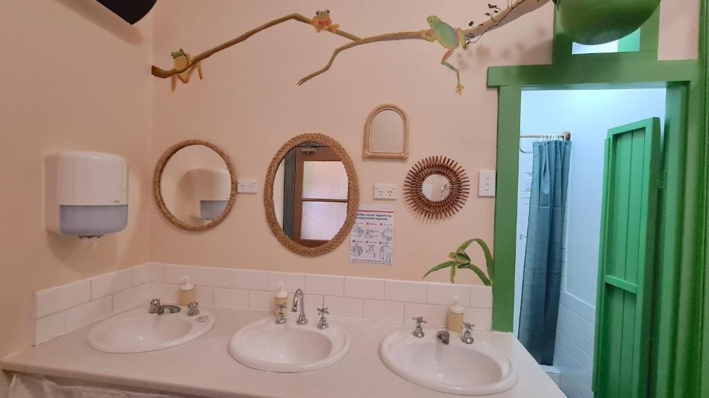 ein Badezimmer mit 3 Waschbecken und Spiegeln und einer grünen Tür in der Unterkunft No14 Lovel St in Katoomba