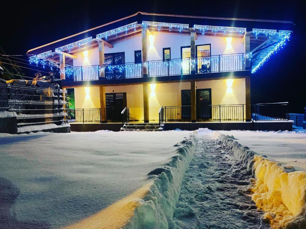 a building with lights on it in the snow at Villa Wild Rooms in Jieţ
