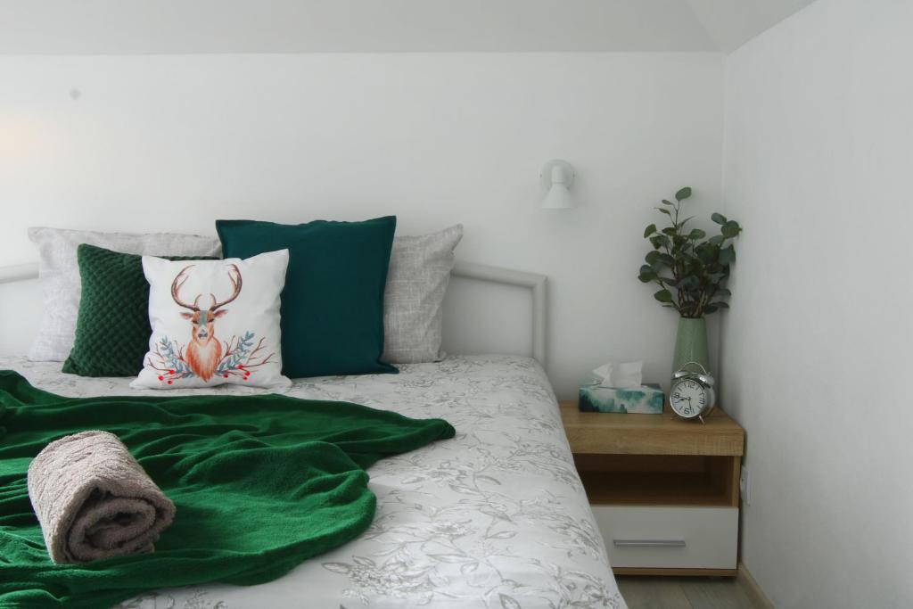 - un lit avec une couverture verte et des oreillers dans l'établissement Ruda Sowa, à Nowa Ruda