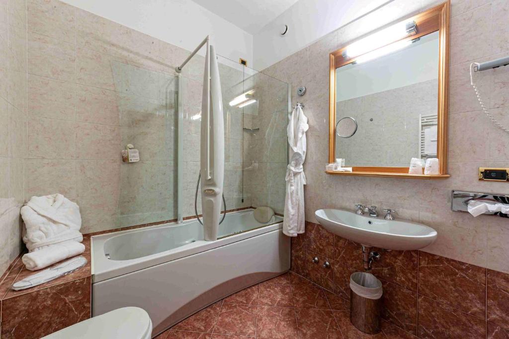 a bathroom with a tub and a sink and a shower at Hotel Cappello D'Oro, BW Signature Collection in Bergamo