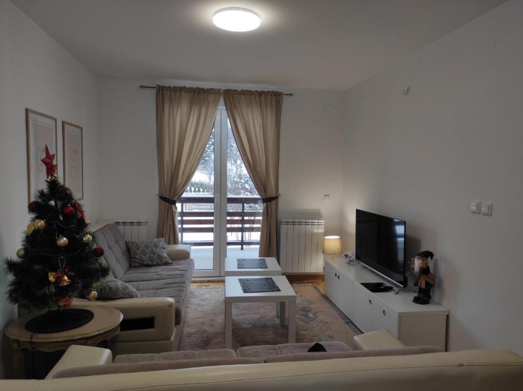 a living room with a christmas tree and a couch at Apartman MiMa in Pale