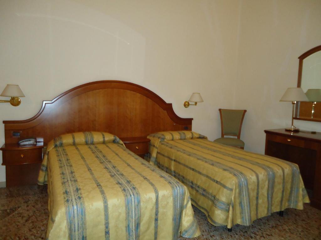 Łóżko lub łóżka w pokoju w obiekcie Albergo Roma