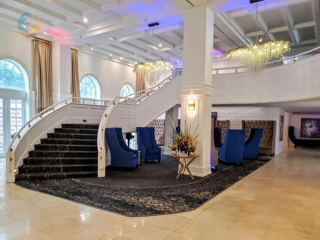 a staircase in a building with blue chairs at Luxury Beach Resort - HORA RENTALS in Miami Beach