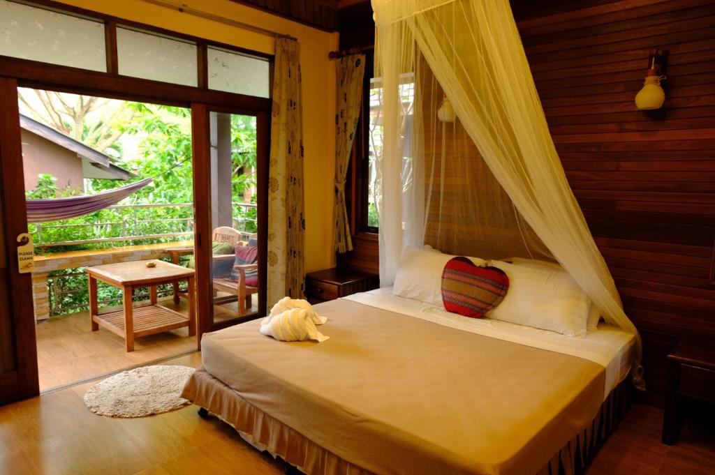 ein Schlafzimmer mit einem Himmelbett in der Unterkunft Pen's Bungalow Koh Phangan in Thong Nai Pan Yai