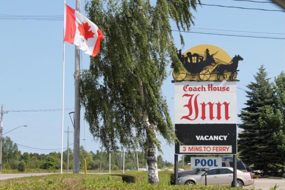 una señal para un concesionario de automóviles con bandera canadiense en Coach House Inn en Tobermory