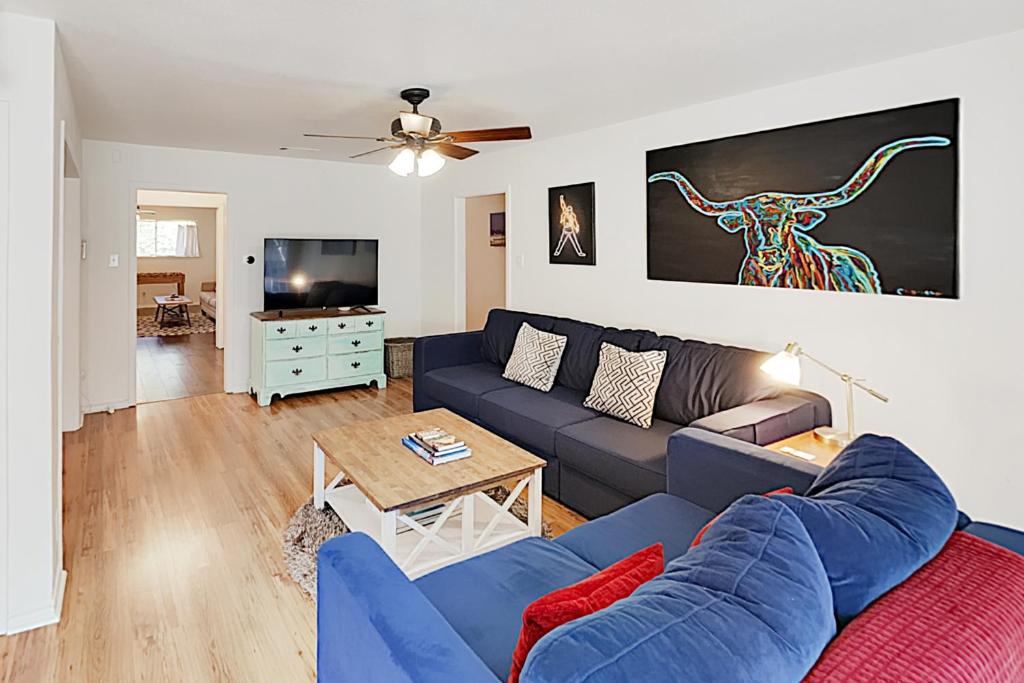 a living room with a blue couch and a tv at South Lamar Home in Austin